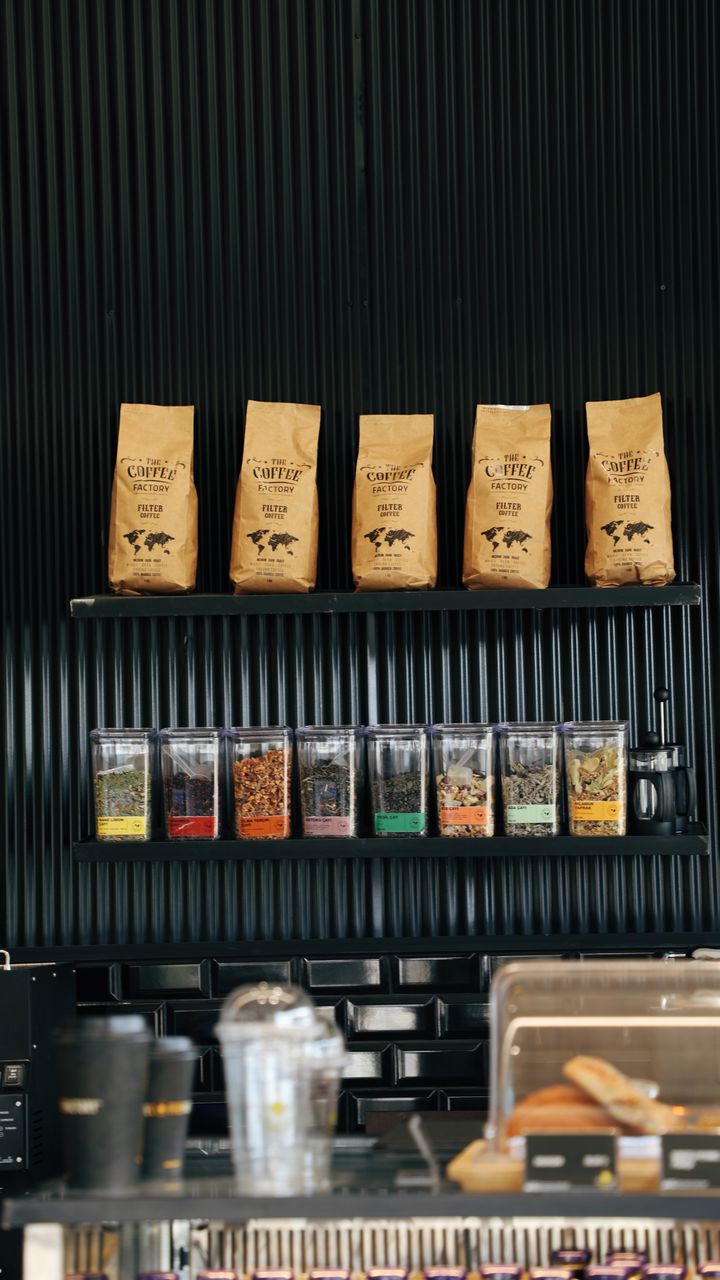 Sleek matte black countertop accents in a modern office coffee bar setup with neutral storage canisters