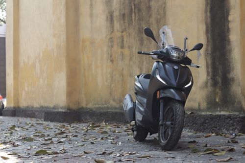 Free A modern black motorcycle parked on a leaf-covered road beside a rustic wall, capturing autumn vibes. Stock Photo