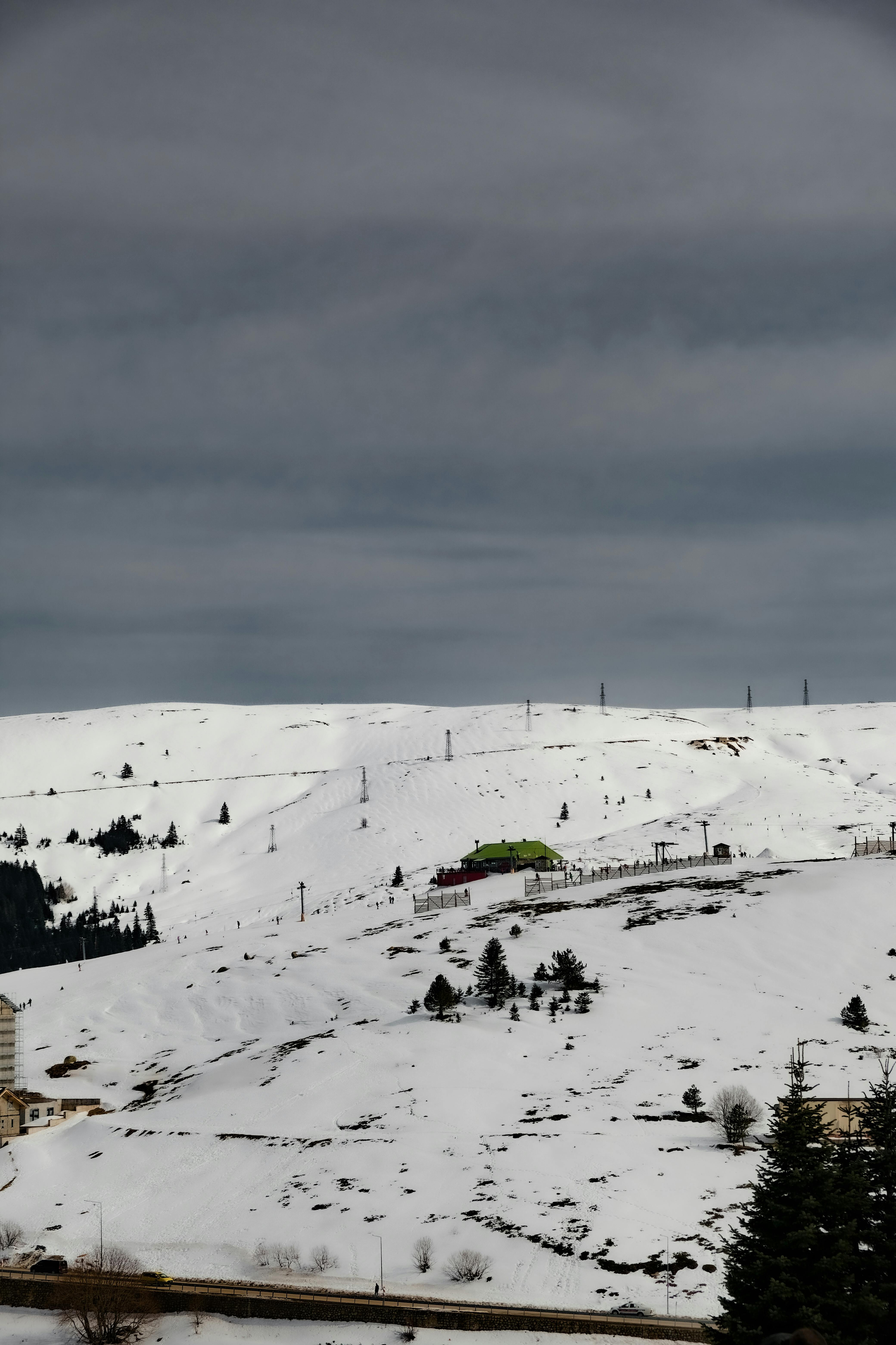 Prescription Goggle Inserts - A serene winter landscape with snow-covered hills and a distant building under a cloudy sky.