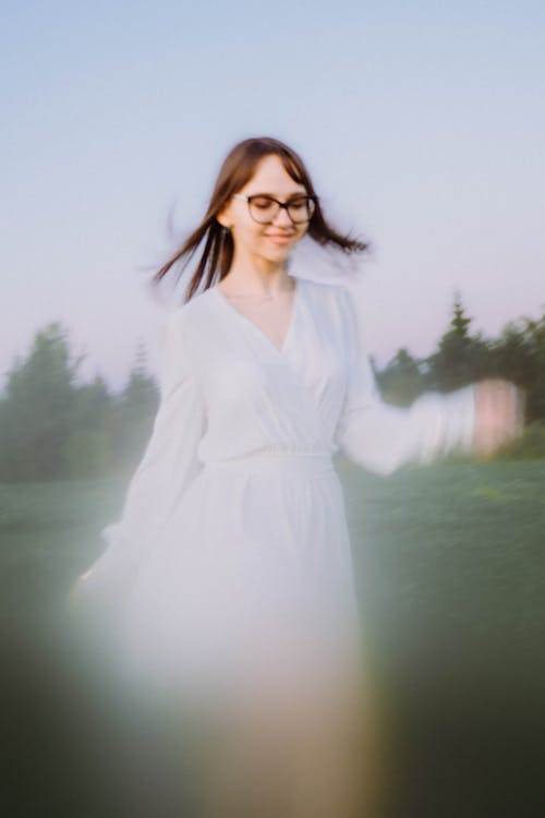 Experimental portrait of a young girl in a white dress with blur in motion 