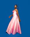 Elegant Black Woman in Pink Dress on Blue Background