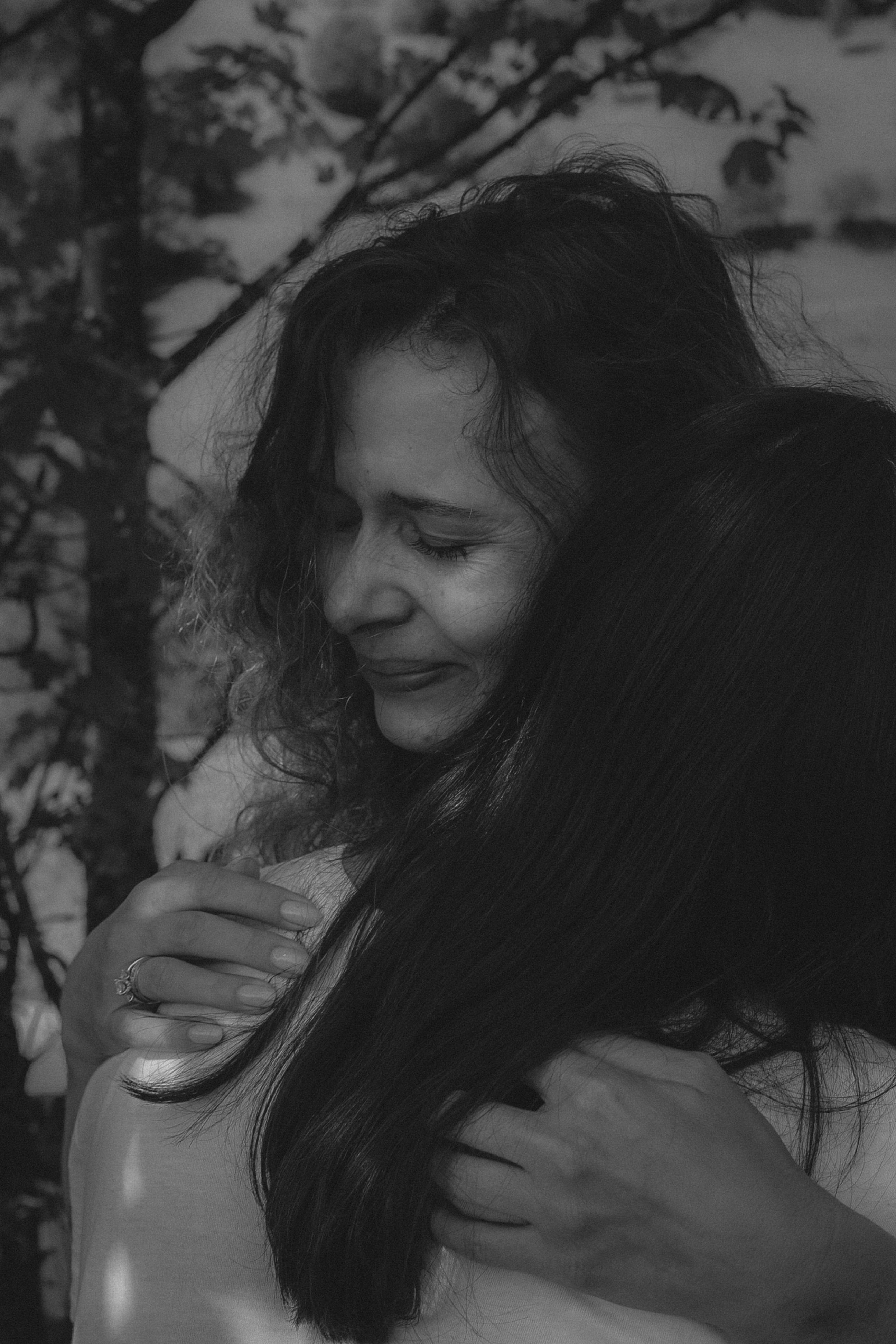 Black and White Photography of a Woman Hugging Another Person