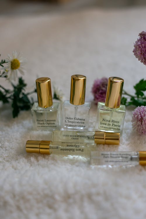 A group of five perfume bottles with flowers