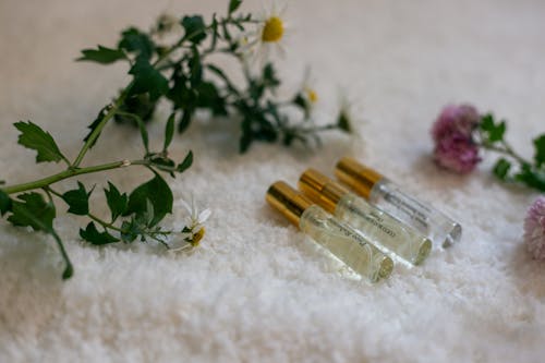A bottle of perfume and flowers on a white towel
