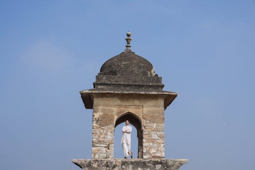Indian Man Standing at the Top of a Stone Tower 