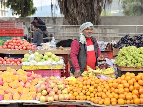 A man standing in front of a fruit stand