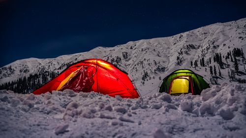 Free Two illuminated tents in snowy mountains under a starry night sky. Stock Photo