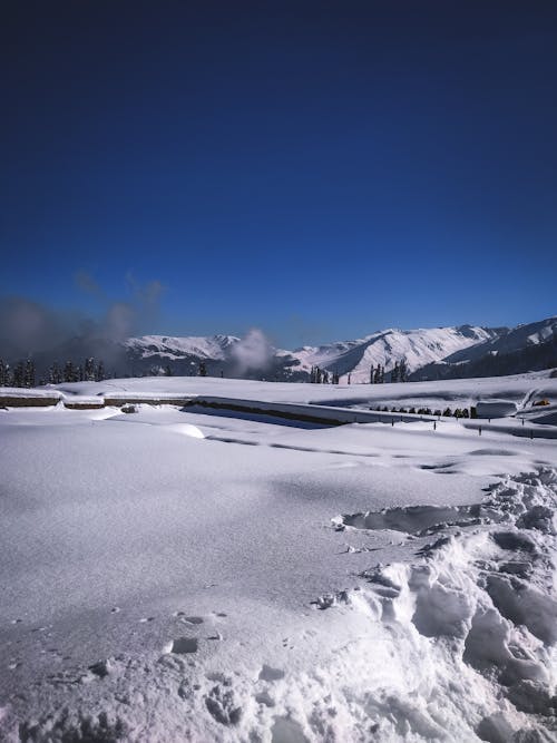 A snow covered field with mountains in the background
