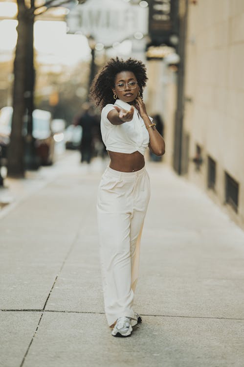 Young Woman in a Casual, Trendy Outfit Walking on a Sidewalk