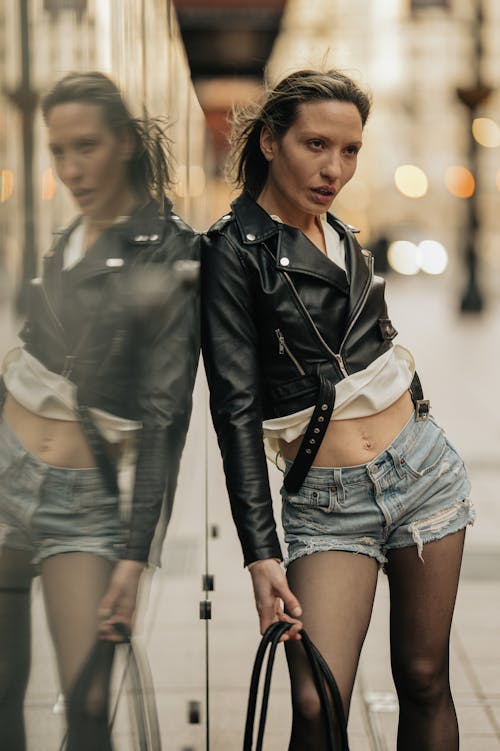 Free A woman in shorts and a leather jacket posing for a photo Stock Photo