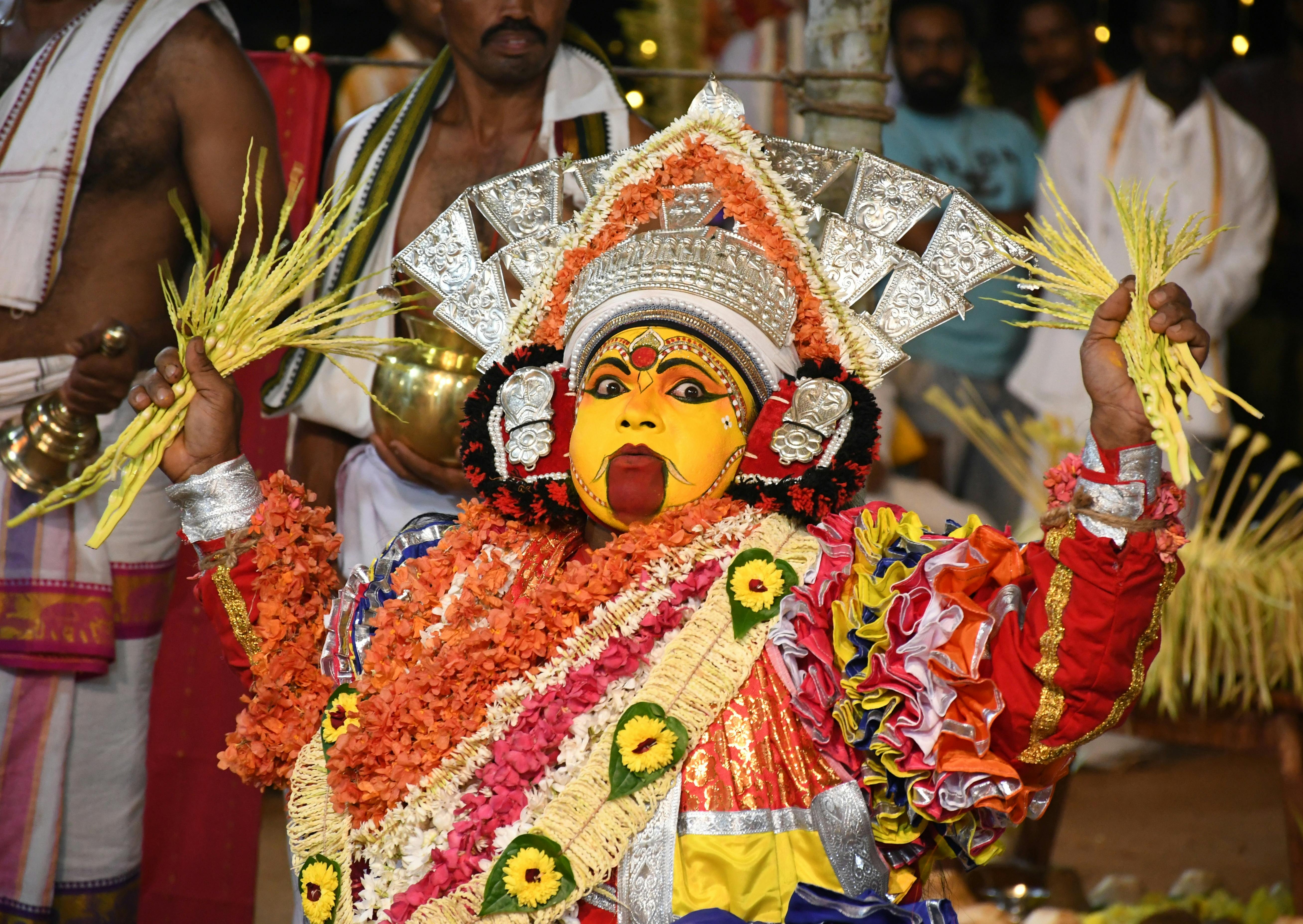 Colorful traditional performer in Mangaluru festival, showcasing vibrant attire and cultural heritage.
