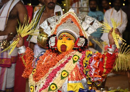 Colorful traditional performer in Mangaluru festival, showcasing vibrant attire and cultural heritage.