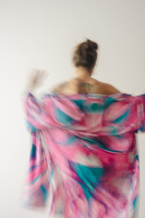 Free A woman in a pink and blue dress is running Stock Photo