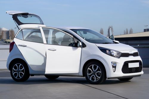 Free White Kia Picanto car with open doors parked outdoors in Harlow, England. Stock Photo