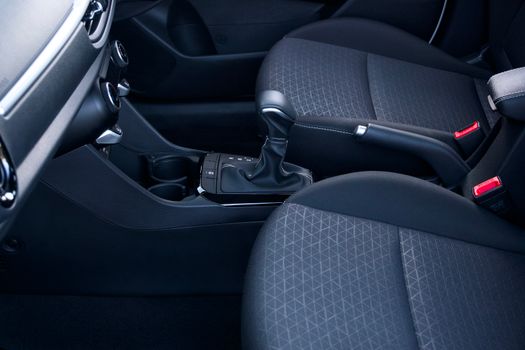 Close-up view of a sleek and modern car interior featuring a gear lever and stylish seats.