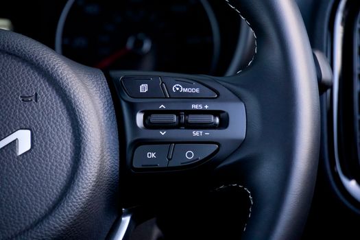 Detailed view of a car steering wheel with control buttons, showcasing modern design and functionality.