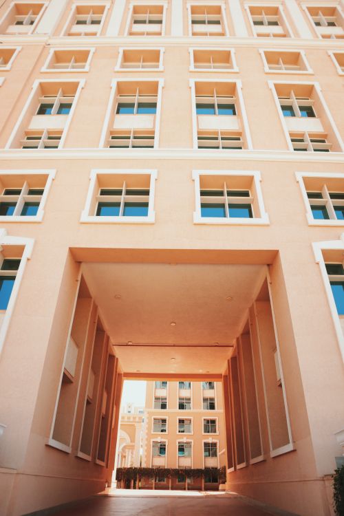 Free This image showcases a modern architectural building with a unique upward perspective, highlighting its contemporary design. Stock Photo