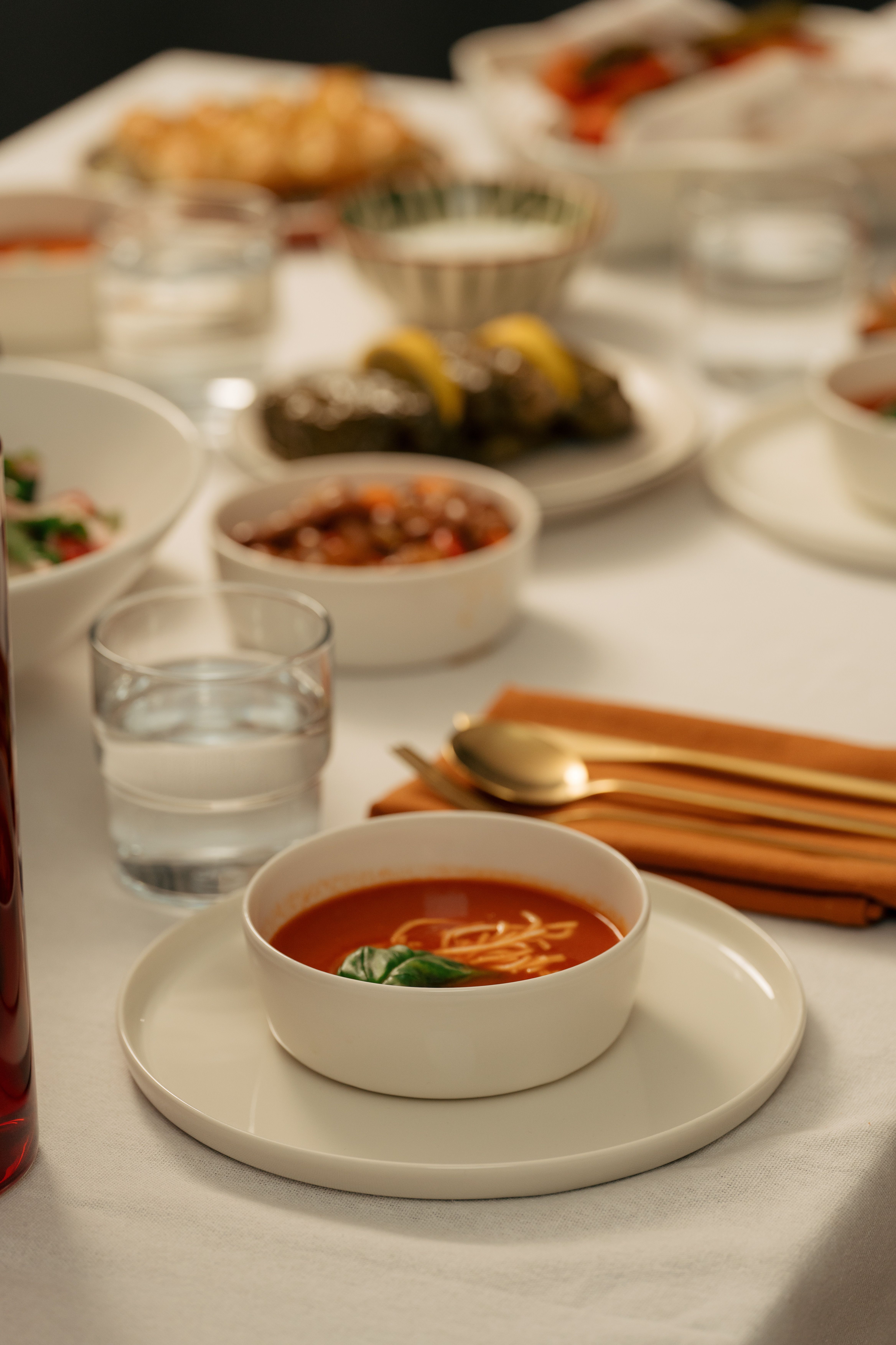 Close-up of a dining table with bowls of food and water glasses, ideal for culinary themes and dining experiences.