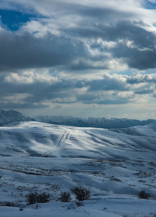 A snowy landscape with mountains and snow covered hills