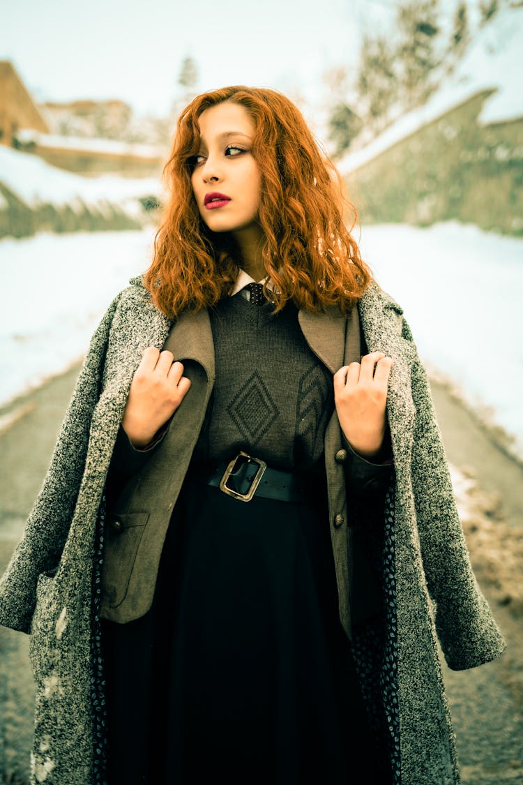 Young, Elegant Woman Wearing A Coat Standing Outside Among Snow 