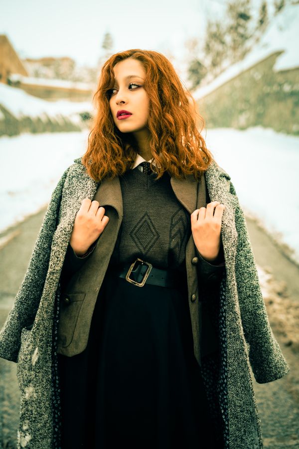 Woman in a long wool coat over a slim knit dress