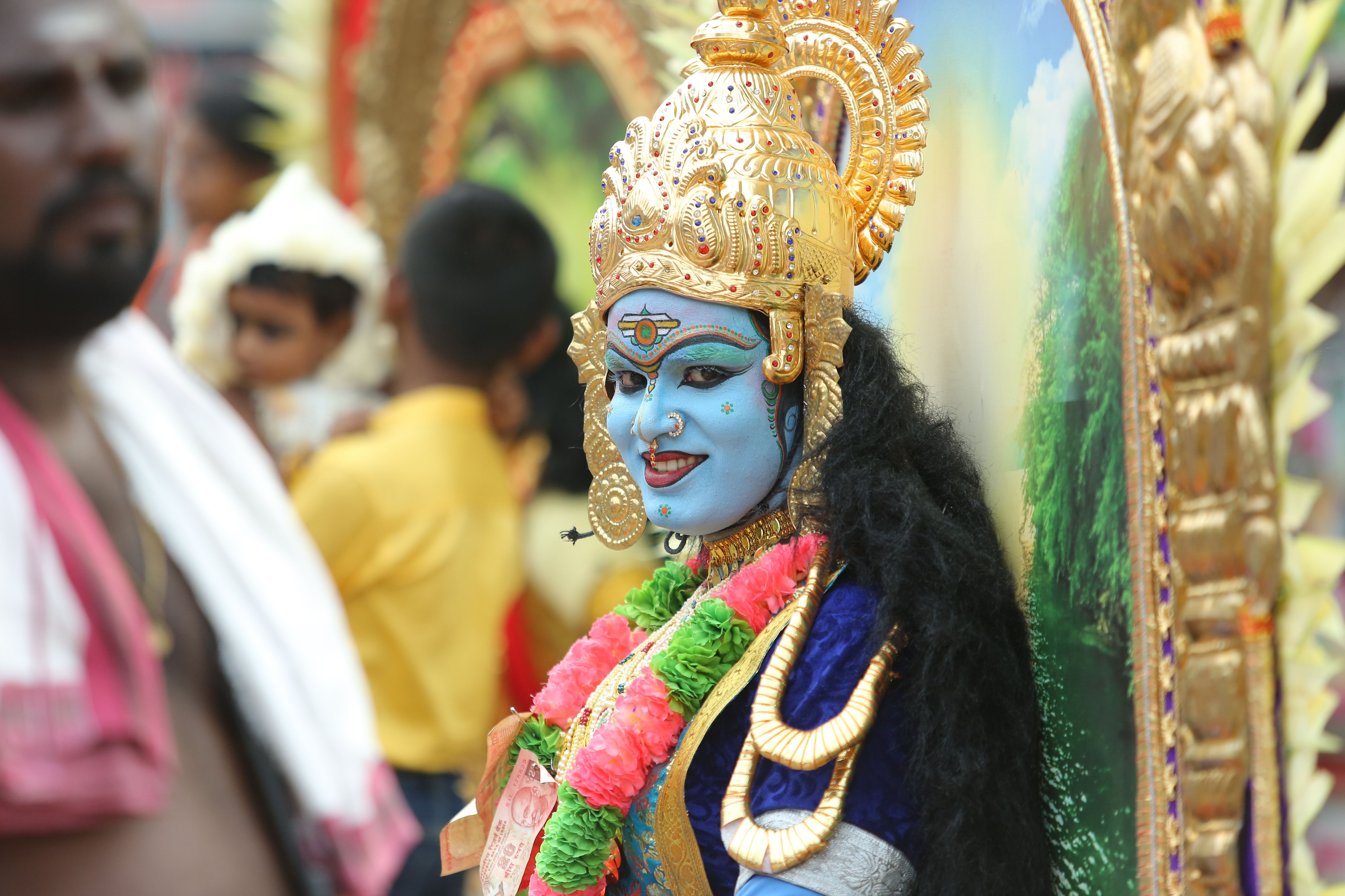 Vibrant portrayal of a performer in traditional Hindu attire during a festival in Thrissur, India.
