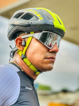 Close-up of a male cyclist wearing a helmet and sunglasses, showcasing sports safety gear.