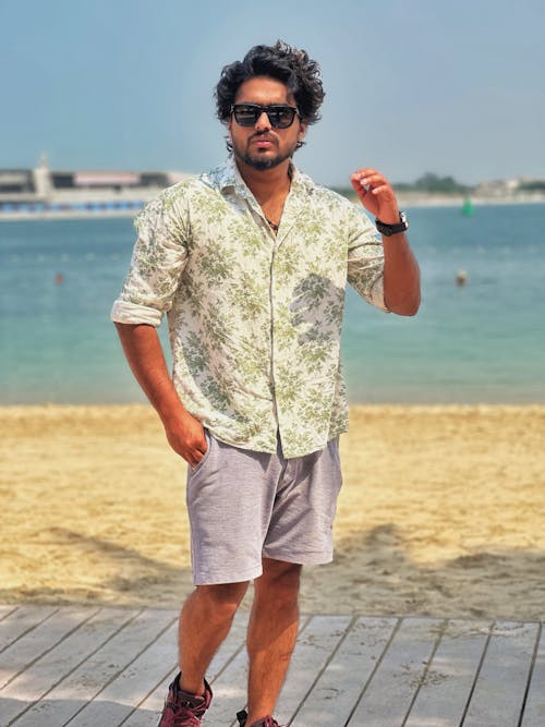 Tourist in a Floral Shirt and Gray Shorts on the Boardwalk by the Beach