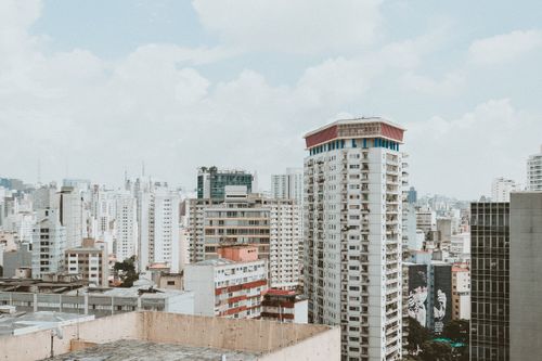 Free Aerial view of a modern city skyline featuring high-rise buildings under a bright sky. Stock Photo