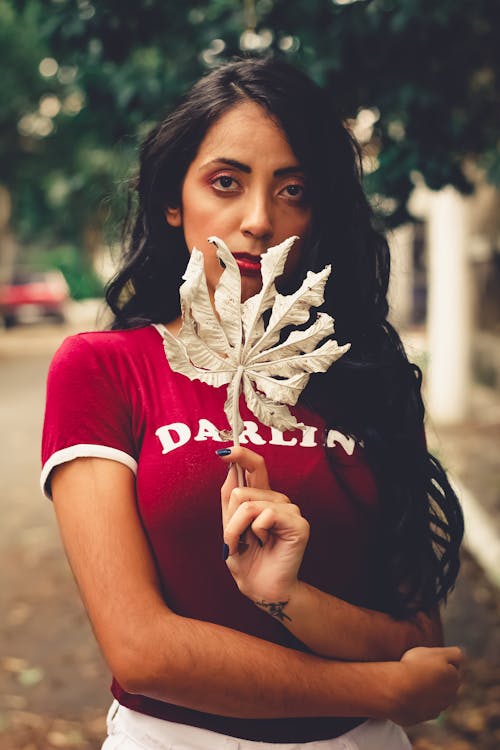 Фотография женщины, держащей сухой лист