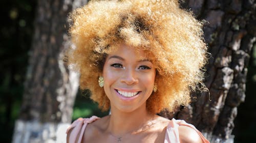 A woman with an afro hair style smiling
