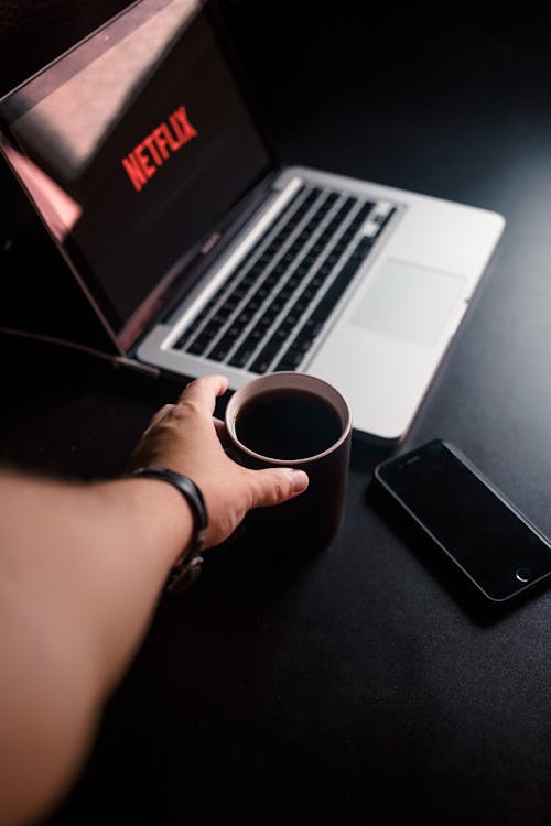 Free Person Reaching for Mug With Coffee Near Macbook Pro and Space Gray Iphone 6 Stock Photo