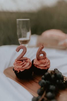 Celebrate a 26th birthday with styled cupcakes, grapes, and champagne in an outdoor picnic setting.