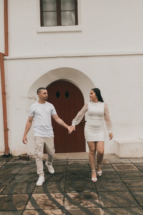 A couple holding hands walking through a doorway