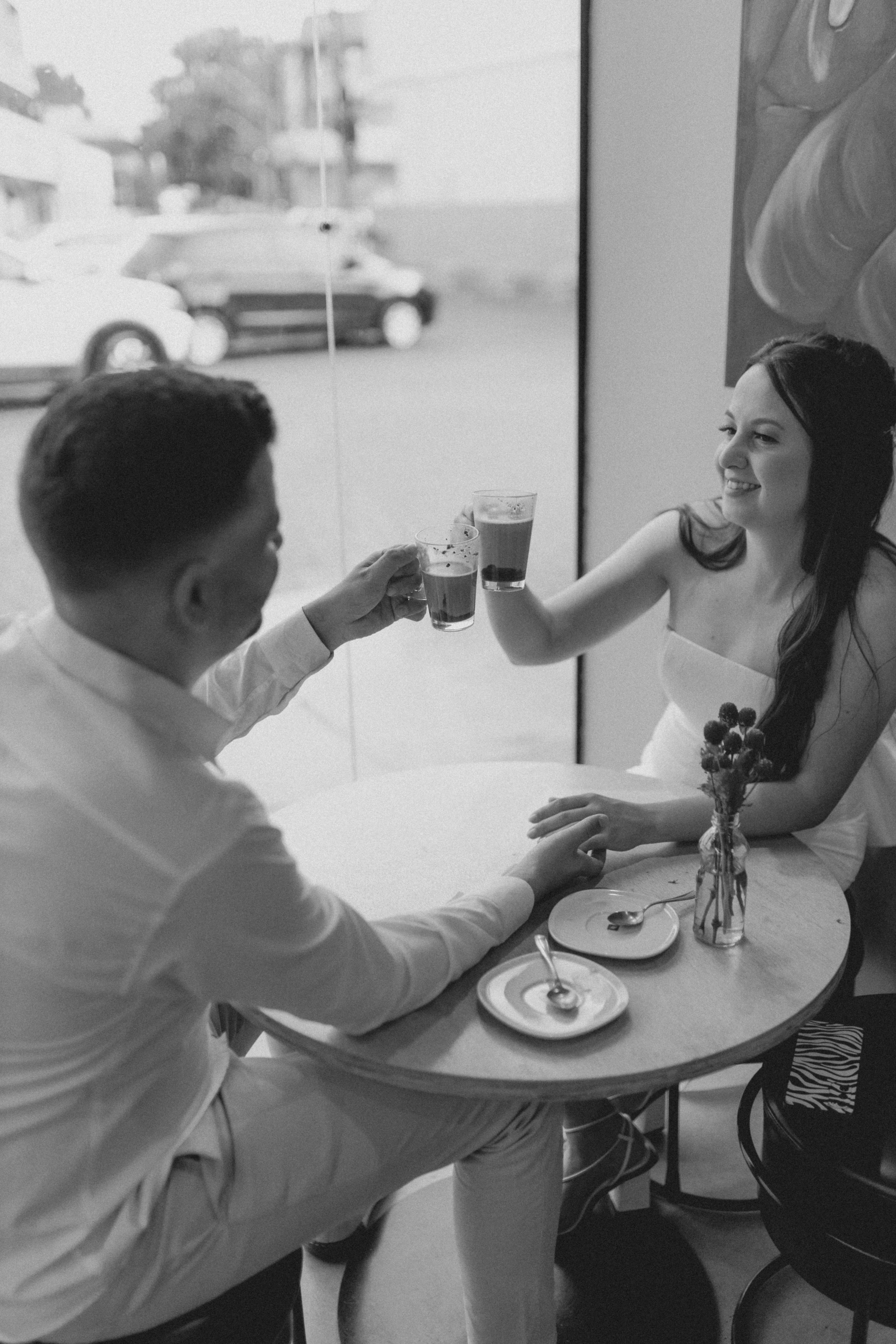 candid photo of couple laughing at a small cafe table