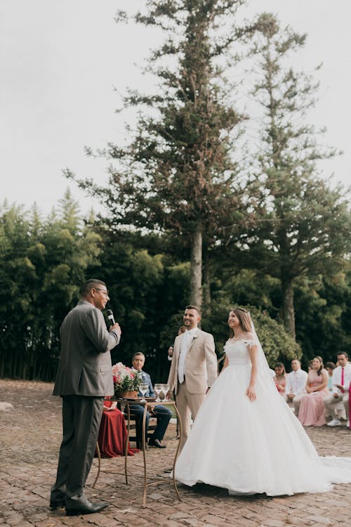 A bride and groom are standing in front of a crowd