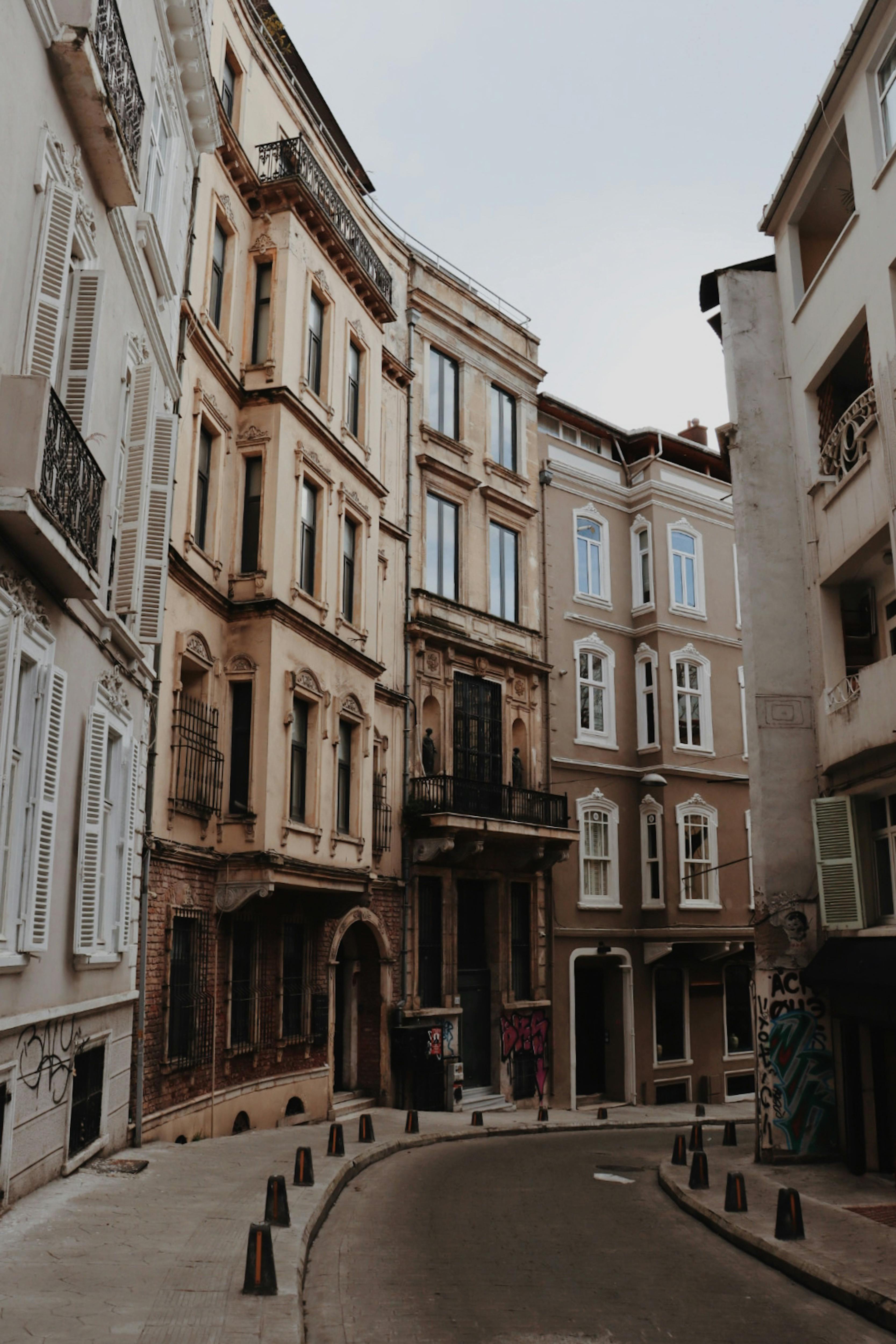 Explore the charm of Istanbul's historic architecture with this narrow street scene in a bustling urban neighborhood.