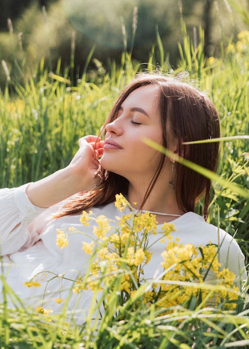 Young Woman Lying on a Meadow with Closed Eyes