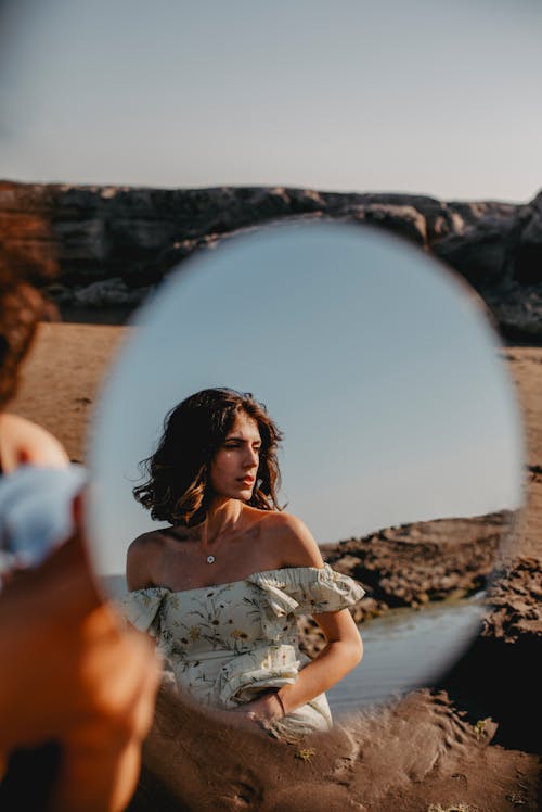 A woman in a dress looking in a mirror
