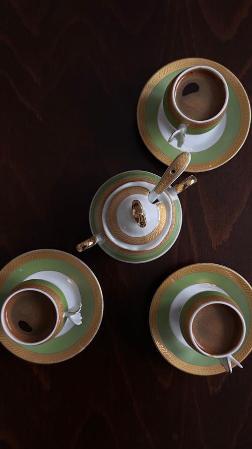 A table with three cups and saucers