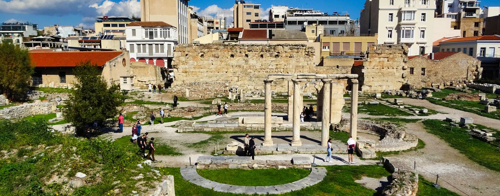 Explore the historic ruins of Hadrian's Library in Athens under a clear blue sky.