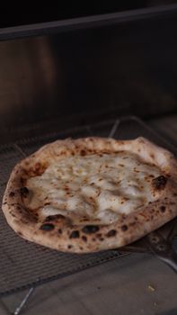Close-up view of a delicious baked cheese pizza with melted cheese in an oven.