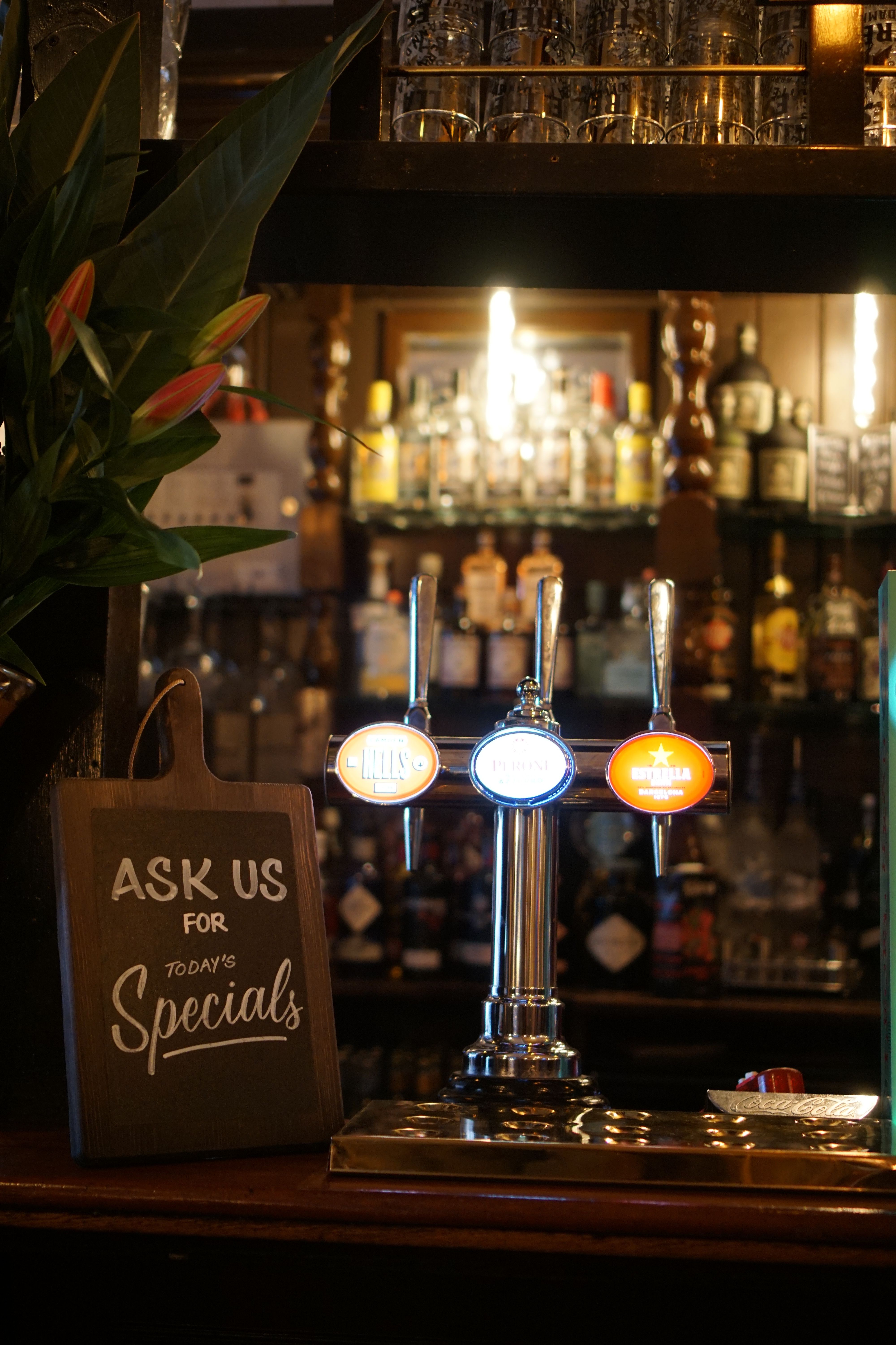 Warm pub setting featuring beer taps and a specials sign, evoking a welcoming atmosphere.