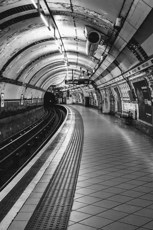 Free Dramatic black and white image of an empty underground subway station tunnel. Stock Photo