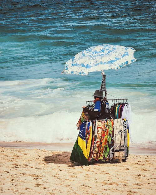 A beach umbrella on the beach with a t-shirt on it