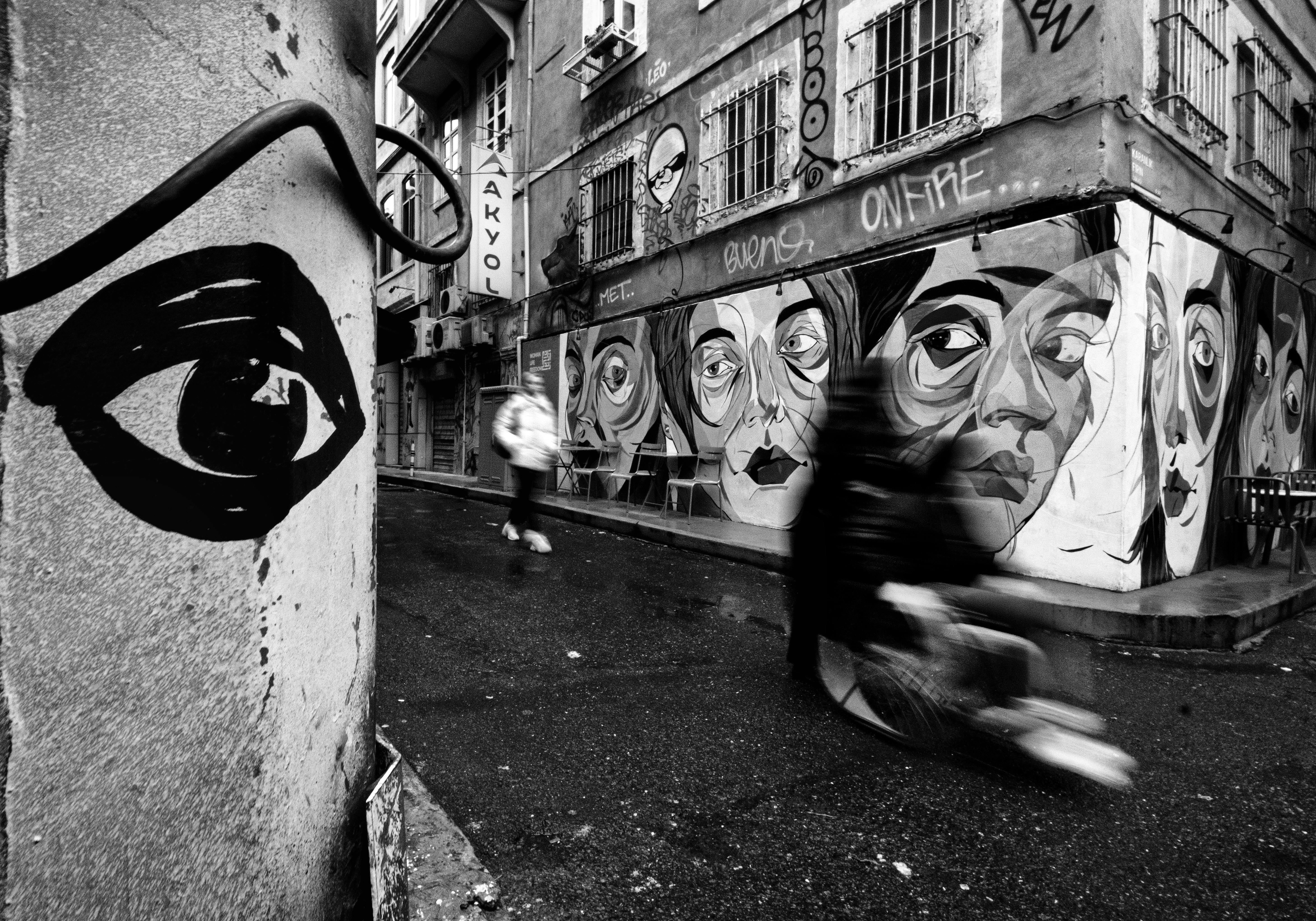 Dynamic black and white street art photo in İstanbul's urban setting featuring graffiti and blurred motion.