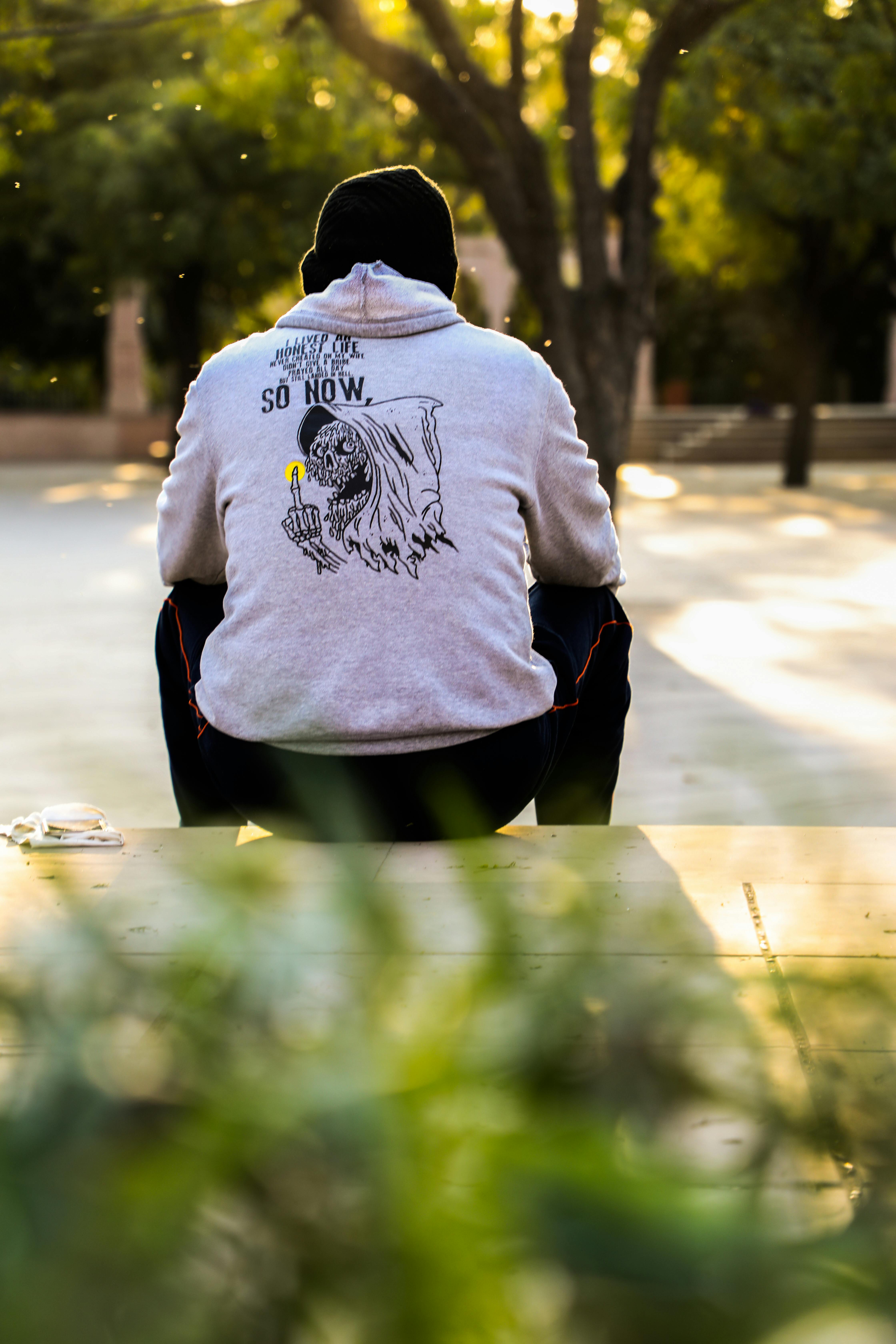 Man sitting on pavement. | Photo: Pexels