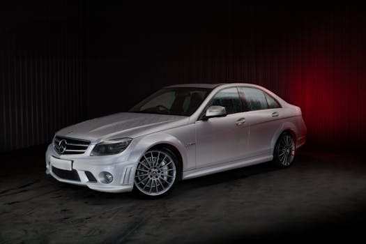 Elegant white sports car displayed in a professional studio setup with a black background.