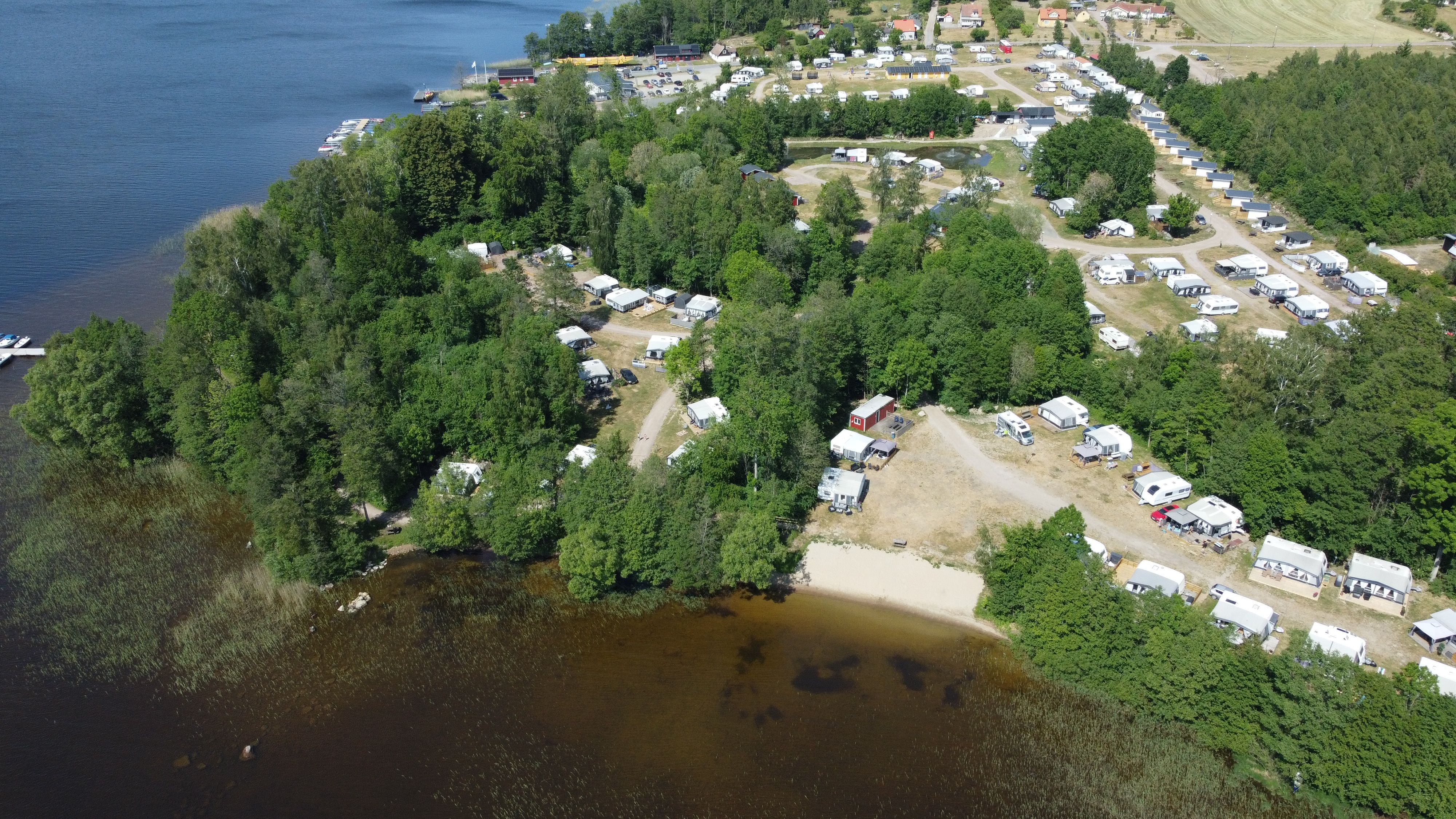 Aerial view of green forests, a lake and a camping area