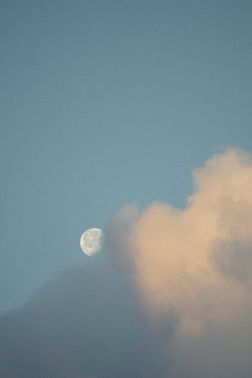 Moon behind Cloud on Blue Sky